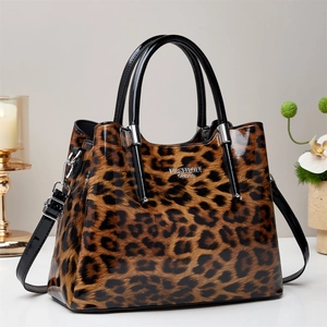 Polished leopard print tote bag with black handles and silver fashion queen emblem