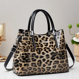 Detail of leopard print tote bag with black patent leather handles and silver logo