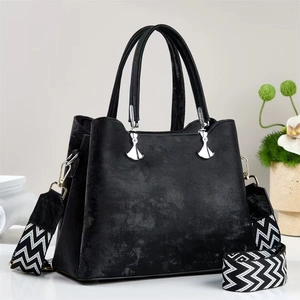 Minimalistische schwarze Handtasche mit Struktur und stilvollem schwarz-weißem Schultergurt