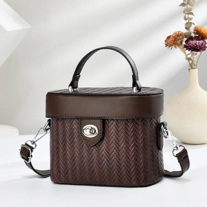 Détail du sac boîte marron foncé avec texture tissée et fermoir rotatif argenté