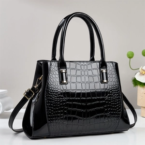 Fashionable black crocodile embossed tote bag with gold hardware and shoulder strap