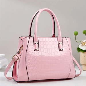 Pink crocodile pattern leather handbag with adjustable strap in a stylish trapezoid shape