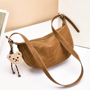 Brown leather crescent crossbody bag with lychee texture and cute bear pendant accessory