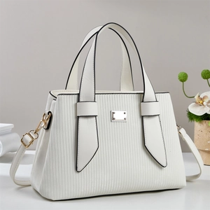 Détail du sac à main blanc avec texture verticale et finitions en métal doré