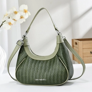 Detail of dark green woven hobo bag featuring silver CSIDESIGN logo and V-pattern leather