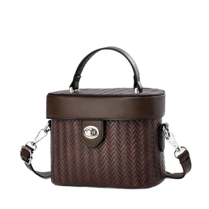 Sac à main boîte marron tressé avec fermoir rotatif argenté et bandoulière sur blanc