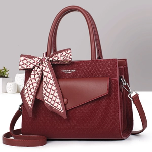 Burgundy woven leather handbag with shoulder strap and decorative bow scarf