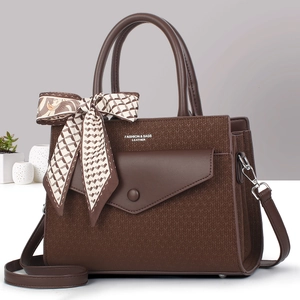 Deep brown leather handbag with fashion lettering and decorative scarf on the handle