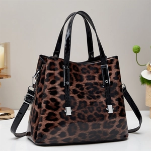 Glossy leopard print tote bag with black handles and adjustable shoulder strap