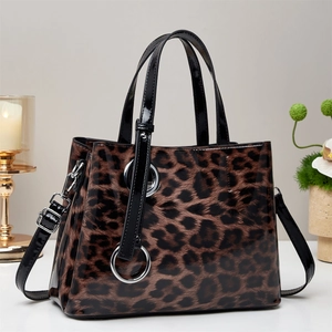 Leopard print faux leather handbag with silver rings and adjustable shoulder strap