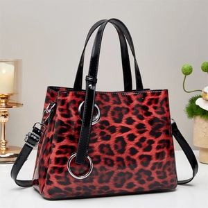 Detail of red and black leopard print handbag with glossy finish and silver ring hardware