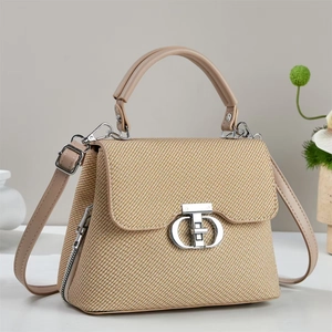 Detail of beige woven texture handbag featuring a silver round twist lock and leather strap