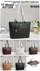 Detail view of woven tote bag with bow charm, pearl pendant and interior compartments