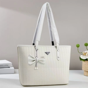 Elegant off-white woven tote bag with bow charm and metallic logo for daily commute