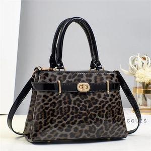 Close-up of leopard print handbag with glossy black trim and gold twist-lock closure