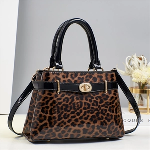 Detail of leopard print handbag with glossy black handles and elegant golden hardware