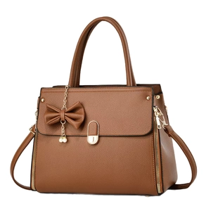 Brown litchi grain leather handbag with gold lock and pearl bow detail in a frontal view