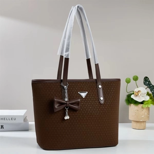 Detail of dark brown tote bag with V-woven texture and pearl bow charm detail