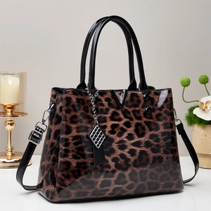 Elegant leopard print patent leather handbag with metal V-detail and a silver charm
