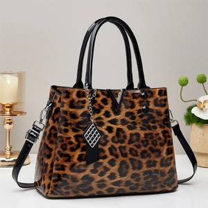 Detail of leopard print handbag with glossy black handles and metallic V hardware