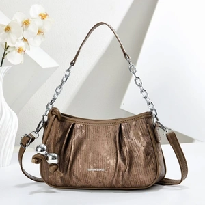Detail of metallic bronze cloud bag featuring silver chain handle and decorative metal spheres