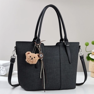 Classic dark grey fabric tote bag with black leather handles and a plush bear charm