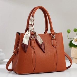 Brown leather tote bag with silk scarf detail and golden hardware for daily commute