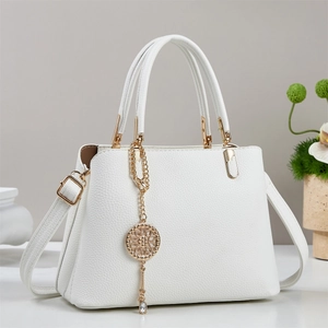 White lychee pattern leather tote bag with gold circular charm and adjustable strap