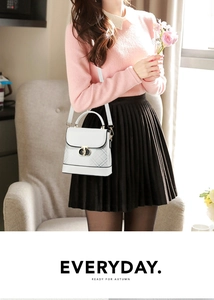 Close-up of a white square handbag with gray plaid pattern and golden twist lock detail