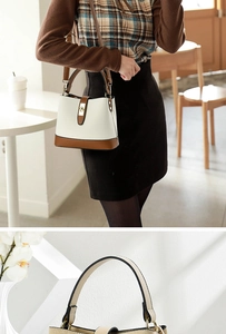 Detail of minimalist bucket bag with cream pebbled leather and brown smooth trim