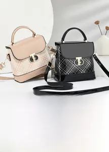 Detail of plaid crossbody bags with glossy leather finish and golden turn-lock buckles