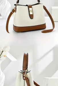 Detail of cream and brown leather bucket bag featuring a gold twist lock and fine stitching