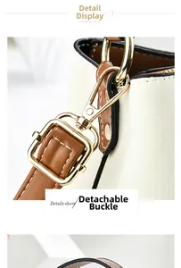 Detail of detachable gold metal clasp on white pebbled leather shoulder bag