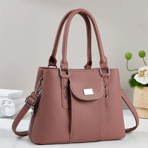 Elegant dusty rose faux leather handbag with top handles and adjustable shoulder strap