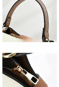 Close-up of contrast stitching on leather bucket bag with premium gold zipper and hardware