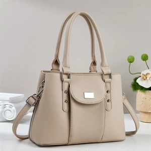 Detail of apricot pebbled leather tote bag with silver hardware and adjustable strap