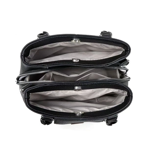 Interior view of black pebbled leather handbag featuring three compartments and fabric lining