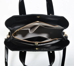 Detail view of the black tote bag interior showing three compartments and gold zipper