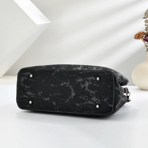 Detail view of the bag bottom with marble pattern and silver protective metal feet