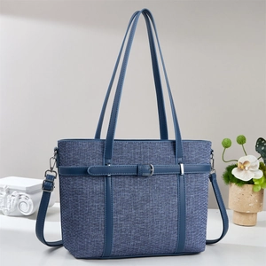 Detail of the blue denim patchwork bucket bag with textured fabric and leather trim