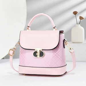 Pink patent leather square bag with lattice pattern and gold T-lock shown on a stone stand