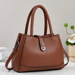 Elegant brown pebbled leather bucket bag with dual handles and silver turn-lock closure