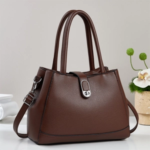 Close-up of brown lychee grain bucket bag with silver metal twist lock and dual handles