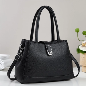 Detail of black lychee grain leather bucket bag with silver metal twist lock and strap