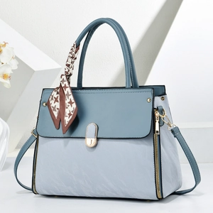 Détail du sac à main bleu-gris avec foulard en soie pied-de-poule et finitions dorées