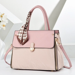 Détail d'un sac à main bicolore en simili cuir avec fermoir métallique et foulard en soie