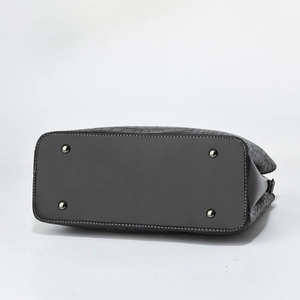 Detail of black leather handbag base with silver studs and white contrast stitching