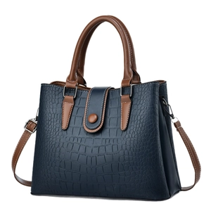 Dark blue crocodile embossed tote bag with brown handles and adjustable shoulder strap