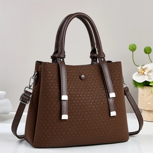 Close-up of dark brown woven texture on women's handbag with silver metal hardware
