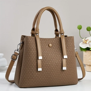 Close-up of brown synthetic leather bag with V-weave texture and silver metal hardware
